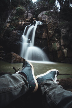 Man sitting in-front of a waterfall