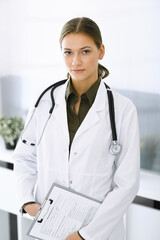 Woman-doctor standing and looking at camera. Perfect medical service in clinic. Medicine and healthcare