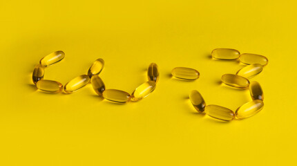 omega 3 gel capsules on yellow background