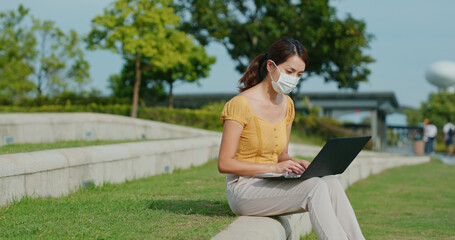 Woman wear face mask and work on laptop computer