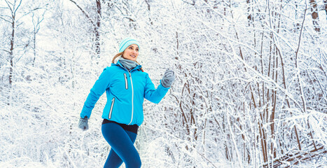 Fit woman running in winter and snow to do her sports exercise