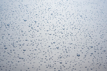 Small drops of water on a gray background.