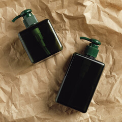 Green pump dispenser bottles on kraft paper. SPA natural cosmetics packaging design, shampoo or soap containers mockups.