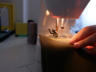 Sewing on sewing machine. Woman sewing at home. Using sewing machine while sewing clothes.Selective focus .