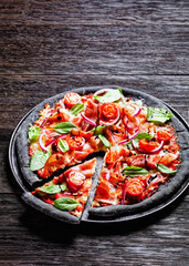 black dough pizza with jamon, top view