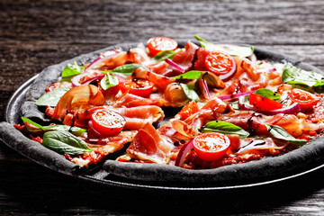 black dough pizza with jamon, top view