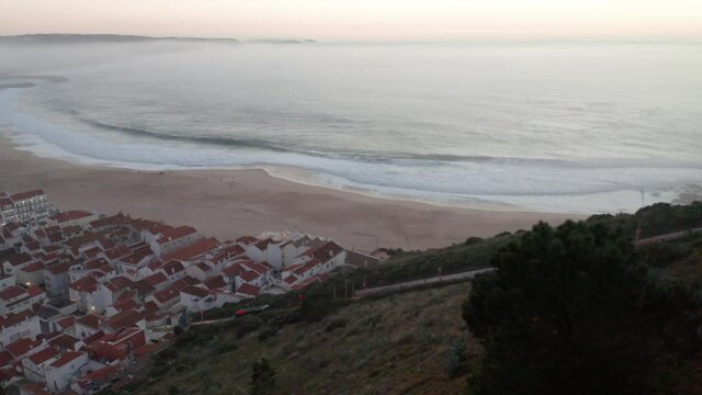 Skyline And Beach Waterfront Of Nazar&eacute; Town In Portugal - aerial pullback