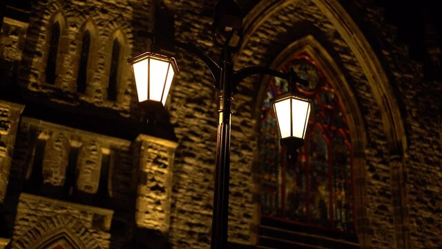 Night time exterior shot of a exterior chandelier style light pole in front of the beautiful and historic Christ Church Cathedral at Sparks Street in Ottawa, Ontario, Canada.