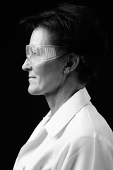 Mature beautiful woman doctor with short hair against black background