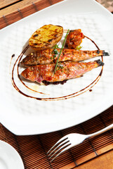 Grilled red mullet on plate with tomato potato and spices