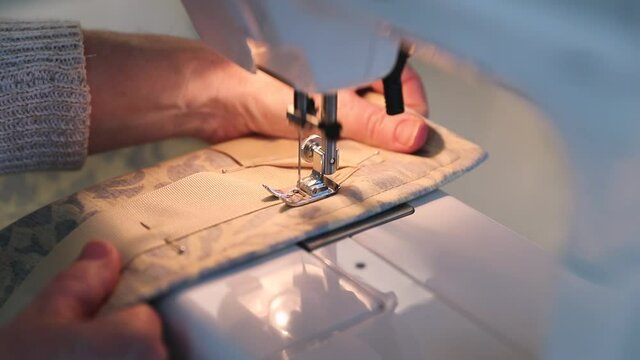 Panning Shot Of Woman Sewing Curtains In Slow Motion.