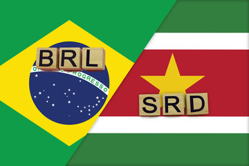 Brazil and Suriname currencies codes on national flags background