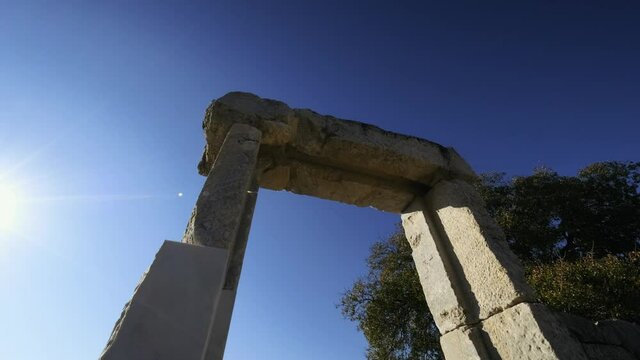 Ancient Greek Stone Arch in Dalyan, Turkey. The sun shines from behind. gate of kounos. 4K.