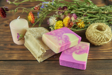 Fototapeta na wymiar Handmade natural soap and various decorative items on the dark wooden countertop.