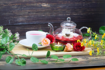 pot and cup of Rose tea on wood background