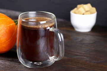 A cup of coffee on wooden table. A glass mug of coffee. Morning coffee