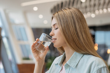 Portrait of young beautiful woman drinking water at home. Healthy lifestyle concept 