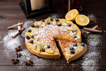 Whole lemon cake as in christmas atmosphere with candles and snow around, catalogue photo