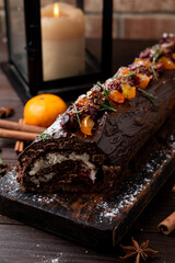 Huge christmas log, covered in melted chocolate, christmas decorations around