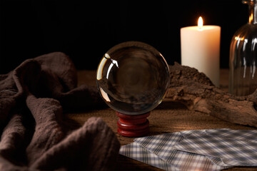 concept of fortune-telling on a wooden table and white candle with a crystal ball and tarot cards...