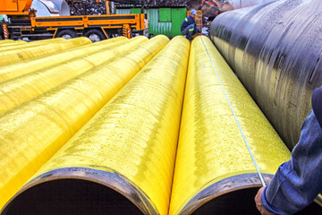 Workers are measuring to polyethylene coated pipes in the factory.