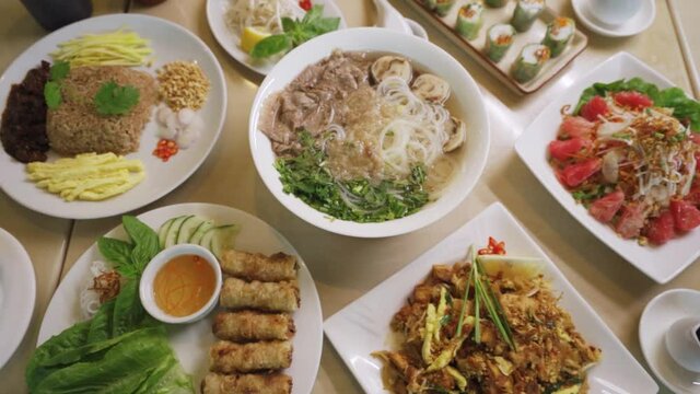 Bowl Of Pho Soup With Plates Of Vietnamese Dish. - zoom out