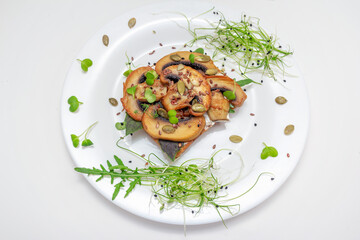 Sandwich with fried mushrooms, basil, pumpkin seeds and microgreens - radish and onion sprouts, served on white plate