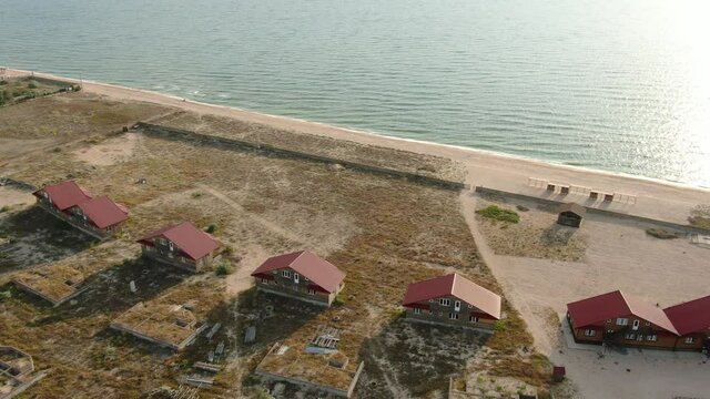 Aerial Drone Footage of Beach Front Houses at Low Tide with Tall Green Grass