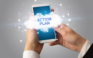 Female hand touching smartphone with ACTION PLAN inscription, cloud business concept