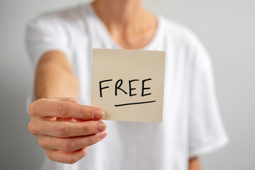 The girl holds a paper sticker with the inscription - Free in her outstretched hand.