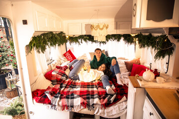 young beautiful couple having fun and relaxing in bed with christmas decorations