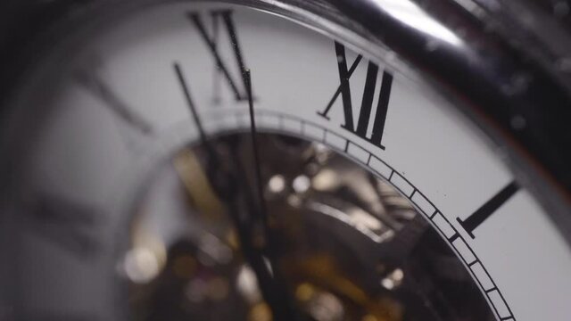 Seconds hand crossing a number on a shiny chrome watch - Macro shot