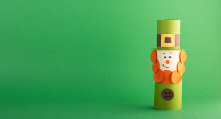 Green cute Leprechaun made of handmade paper on a green background, space for text