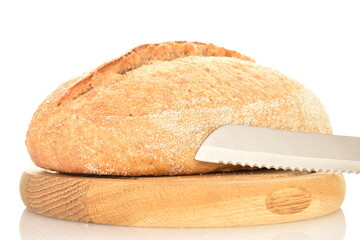 One fresh loaf without yeast with bran cereal on a round wooden tray with a metal knife, close-up, isolated on white.