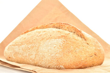 One fresh loaf without yeast with bran cereal with paper bag, close-up, isolated on white.