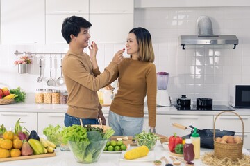 Asian man and woman couple family eating healthy food together with smile and happy emotion in modern kitchen room