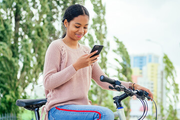 Obraz premium asian woman taking a a bicycle for a rent in downtown by phone app