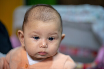 3 Month old baby girl with tears falling down her face