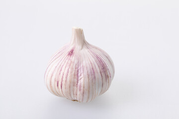 Unpeeled garlic bulb closeup on a white background 