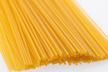 Raw spaghetti pasta without packaging on white background before cooking 