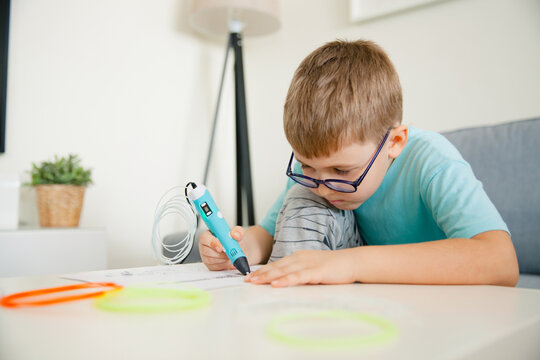 Preschooler boy using 3D printing pen. Boy making new item. Creative, technology, education concept