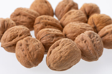 Unpeeled walnuts closeup on white 