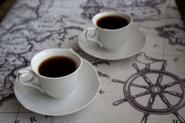 Two white cups of coffee on the table