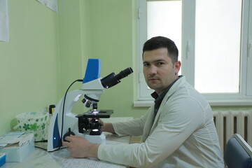 scientist looking at microscope in laboratory