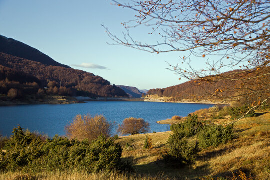 Italian mountain pass with lake and autumn foliage forest, Lagastrello