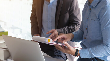 financial Image of two business people pointing at business document presentation summary report , during discussion at meeting , Notebook on wood table