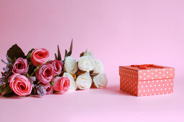 Colorful rose with gift box on pink background