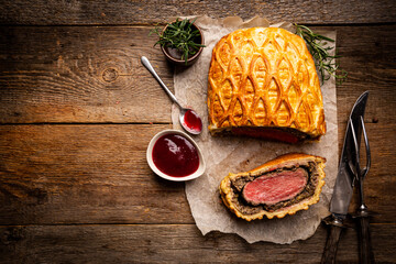 Perfect homemade juicy Beef Wellington, tenderloin dish on rustic wooden table, top view