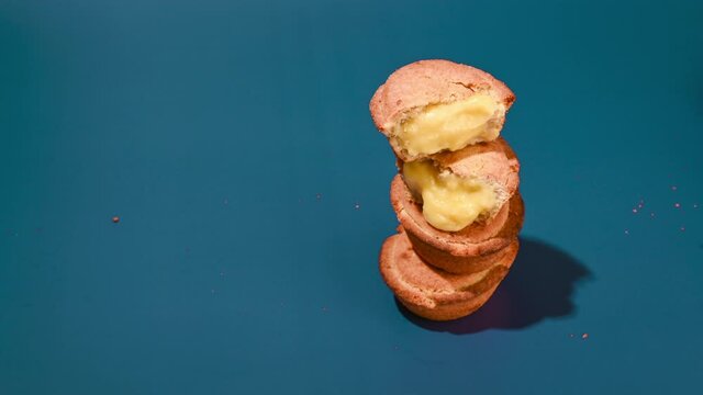 Pasticciotti . Typical pastries from the south of italy, the Apulia region. Buns with cream on a blue background. Hard light in hard light,  