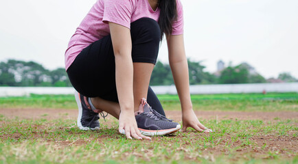 asian woman athlete getting ready to start running on track